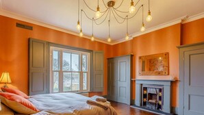 A bedroom with a large bed, a fireplace, and a view through a window. - 5 Bed in Sandown (oc-87008) (Sandown)