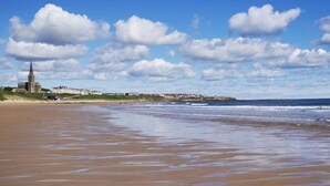Une plage avec une église et des bâtiments en arrière-plan.