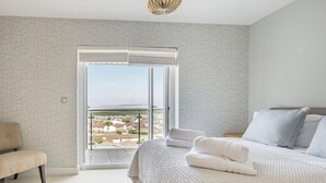 A bedroom with a bed, a bench, and a view through a sliding door. - 4 Bed in Bideford (oc-87428) (Northam)