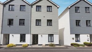 A row of modern, two-story townhouses with a uniform facade, small front yards, and a clear sky. - 4 Bed in Bideford (oc-87428) (Northam)
