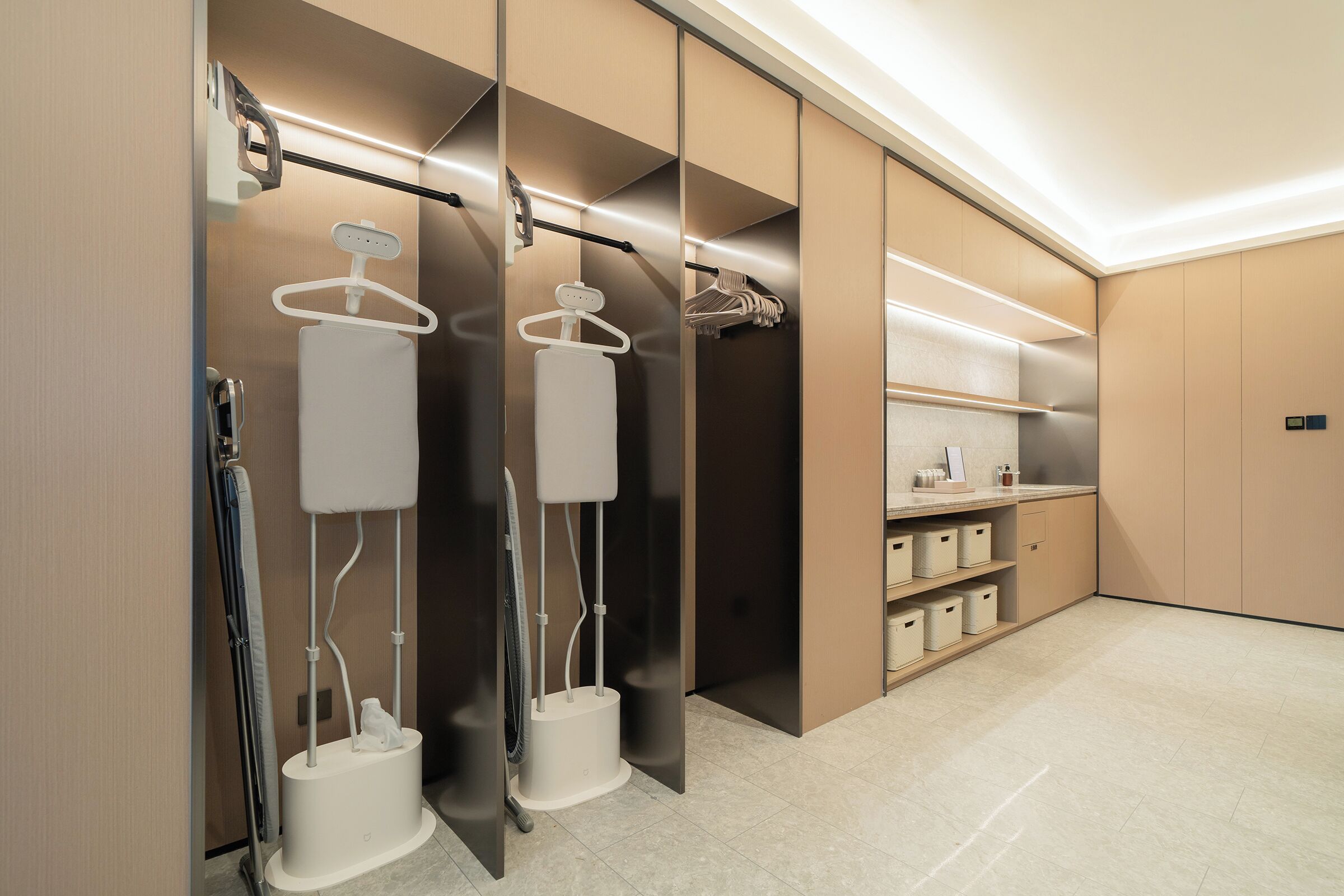 A modern bathroom with a walk-in shower, towel racks, and storage cabinets.