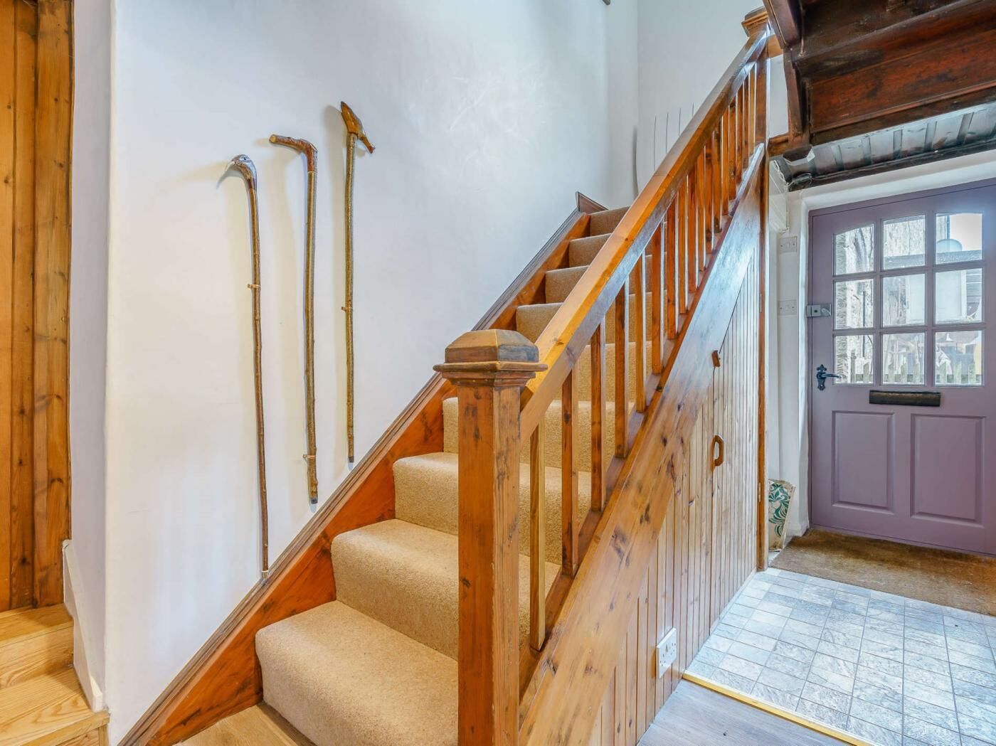 Una escalera de madera con peldaños alfombrados que lleva a una plataforma.