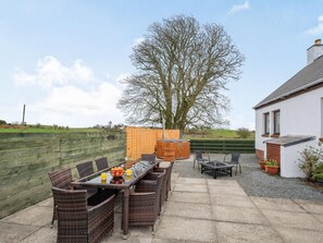 An outdoor patio with a dining table and chairs, a hot tub, and a view of a tree and a building. - 3 Bed in Newton Stewart (oc-87541) (Mochrum)
