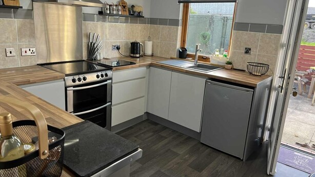 A compact kitchen with a gas stove, oven, sink, and dishwasher. - 3 Bed in Newton Stewart (oc-87541) (Mochrum)