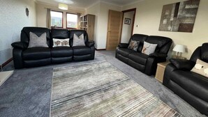 A living room with a sectional sofa, a rug, a lamp, and a painting on the wall. - 3 Bed in Newton Stewart (oc-87541) (Mochrum)