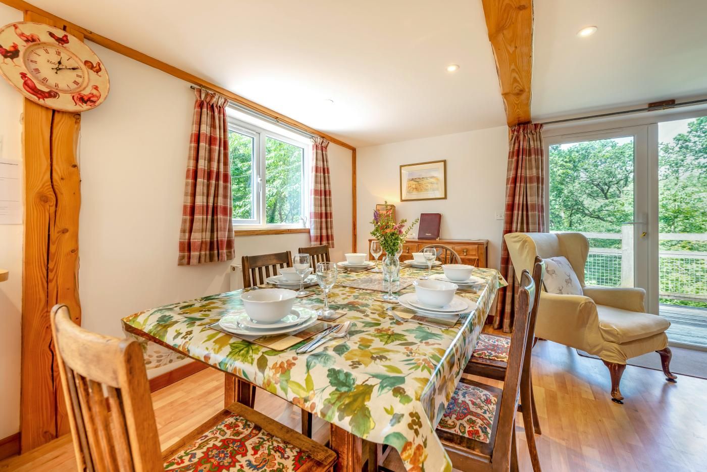 A dining area with a long table, chairs, and a clock on the wall.