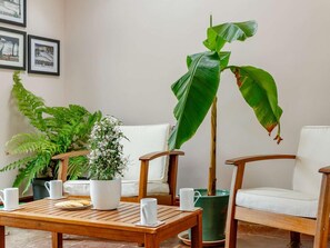 A room with a wooden table, white chairs, a potted plant, and framed pictures on the wall. - 2 Bed in Appleby-in-westmorland (oc-87537) (Long Marton)