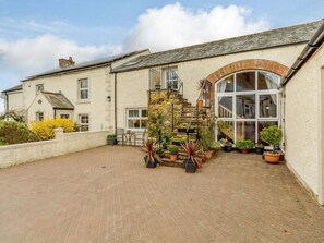 A building with a brick courtyard, a stone staircase, and a large arched window. - 2 Bed in Appleby-in-westmorland (oc-87537) (Long Marton)