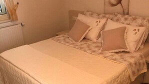 A bedroom with a bed, a radiator, and a window. - Deluxe Two Bedroom Apartment with Terrace (Supetar)