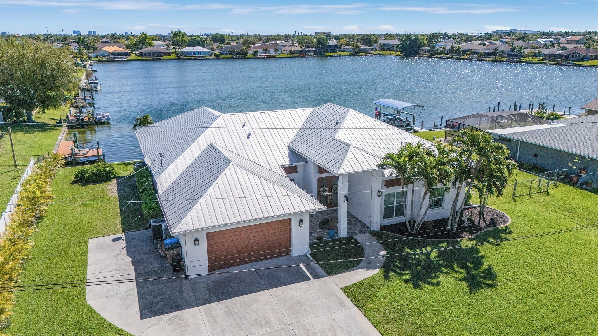 A house with a garage, a covered porch, and a view of a lake.