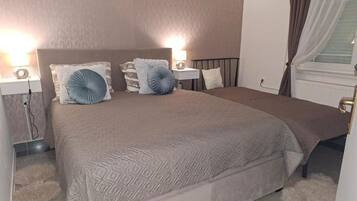 Une chambre à coucher avec un lit, des lampes de chevet et une fenêtre avec des rideaux.