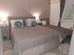 A bedroom with a bed, bedside lamps, and a window with curtains. - Classic One Bedroom Apartment with Terrace (Vukovar)