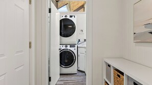 A laundry room with two washing machines, a sink, and a wooden ceiling. - The Grove at Mutiny Bay by Avantstay Walk to Beach Shared Pool + Pickleball Court + Water Views (Freeland)