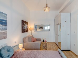A modern bedroom with a bed, bedside table, lamp, and artwork. - Two Bedroom Apartment with Terrace and Sea View (Omis)