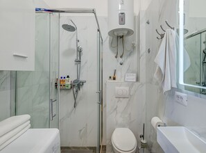 A modern bathroom with a glass-enclosed shower, a toilet, and a sink. - Two Bedroom Apartment with Terrace and Sea View (Omis)
