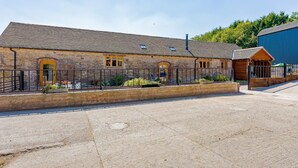 A stone building with a tiled roof, a fenced courtyard, and a small wooden structure. - 4 Bed in Church Stretton (oc-87695) (Gretton)