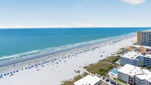 A beach with umbrellas, a swimming pool, and buildings in the background. - 22nd-Floor Oceanfront Luxury · Maisons Sur-Mer (Myrtle Beach)