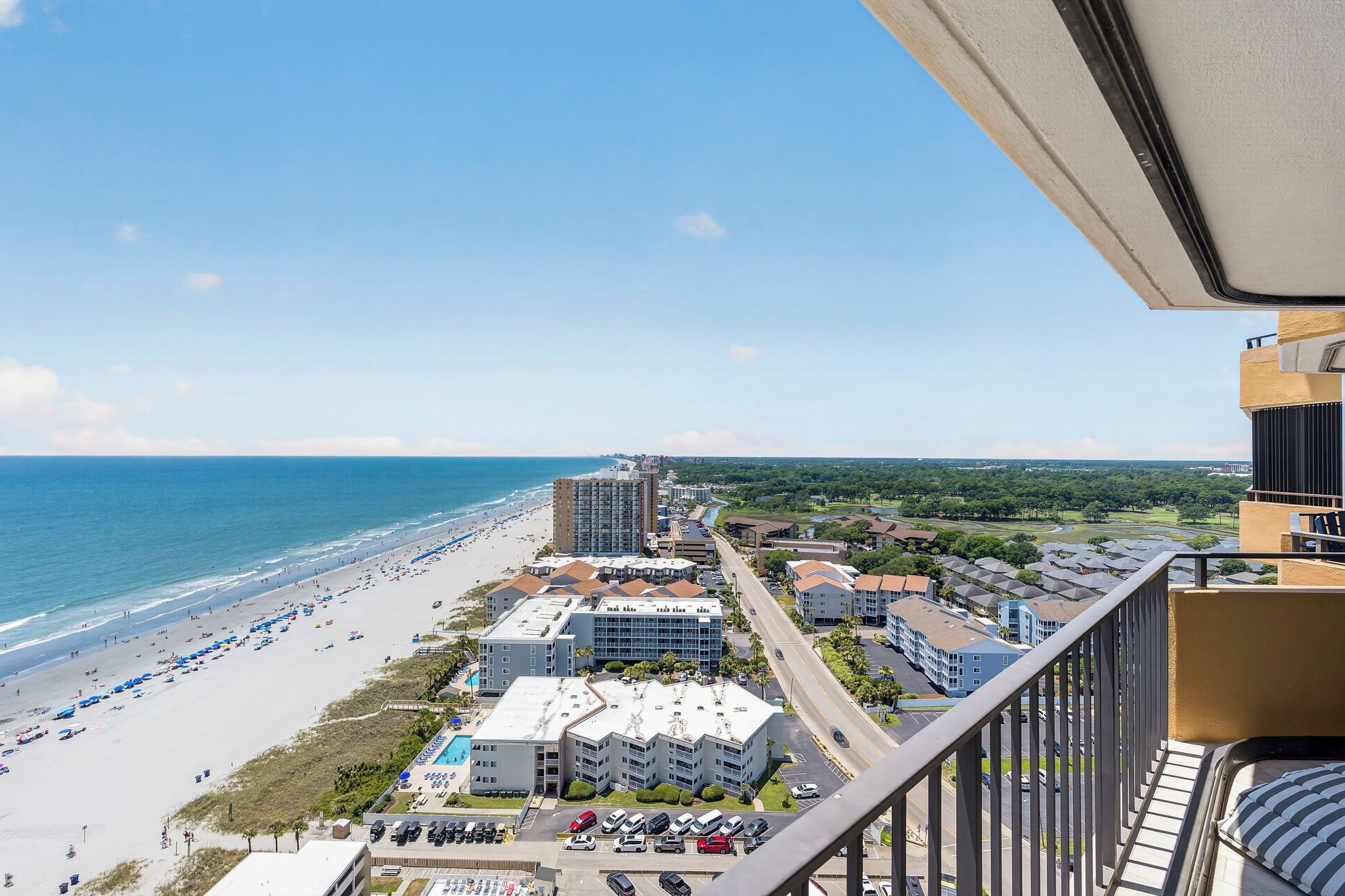 A coastal hotel with multiple buildings, a beach, and a view of the ocean.