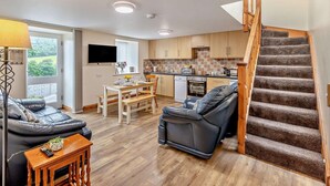 A modern apartment with a living room, dining area, kitchen, and a staircase. - 2 Bed in Bala (oc-87274) (Llandderfel)