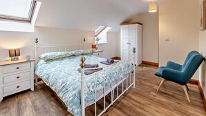 A bedroom with a bed, bedside table, lamp, wardrobe, chair, and skylight. - 2 Bed in Bala (oc-87274) (Llandderfel)