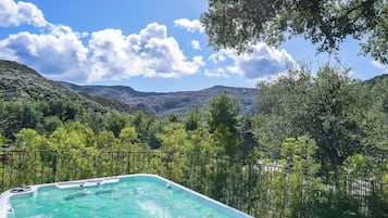 Uma banheira de hidromassagem rodeada por vegetação exuberante e montanhas.