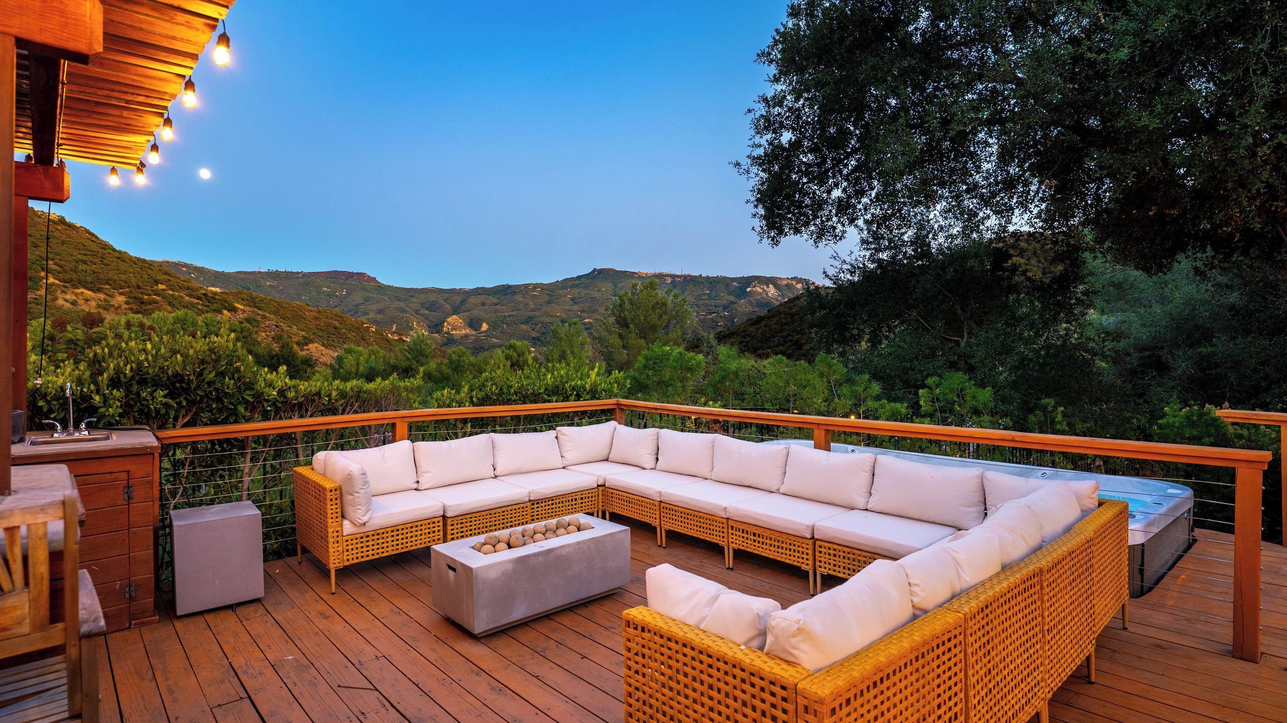 Une terrasse avec un canapé modulable, une petite table et un jacuzzi.