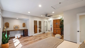 A modern interior with a wooden desk, a white chair, a ceiling fan, and a large wooden cabinet. - Dreamsawake by Avantstay Saltwater Pool Swim Spa + Firepit Private Canyon Views (Calabasas)