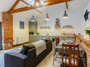 A cozy kitchen with a dining area, exposed wooden beams, and a brick wall. - 1 Bed in York (oc-87323) (Tockwith)