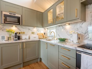 Una cocina con encimeras de mármol, horno empotrado y muebles de cocina modernos.