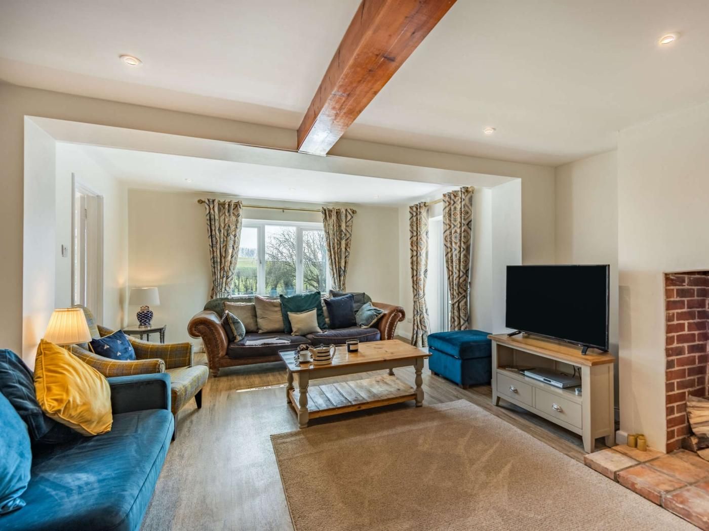 A living room with a sofa, a coffee table, a TV, and a fireplace.