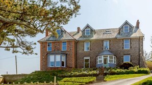 A two-story house with a stone facade, a bay window, and a small turret. - 3 Bed in Woolacombe (oc-87573) (Mortehoe)
