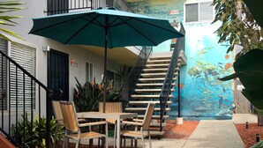 A residential building with a staircase, outdoor seating, and a mural. - Quiet PB Retreat w/ Cal KING Bed, AC & Parking (San Diego)