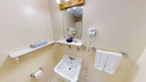 Baño con lavamanos, espejo, toallero y secador de pelo.