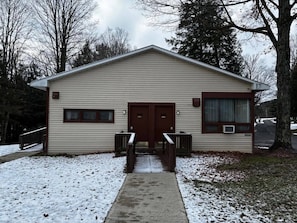 A single-story building with a front entrance, a small porch, and a covered area with a bench. - Cozy 1-bedroom hotel room, Hamilton - #304 Mohawk (Hamilton)