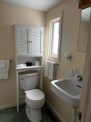 A compact bathroom with a toilet, a sink, and a cabinet. - Cozy 1-bedroom hotel room, Hamilton - #304 Mohawk (Hamilton)