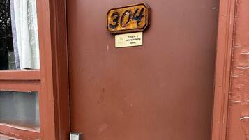 A brown door with a number plate reading '304' and a sign stating 'This is a non-smoking room.'