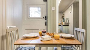 A dining area with a table set for breakfast, including croissants, a ham platter, and orange juice. - 1 Bed in Wadebridge (oc-87740) (Wadebridge)