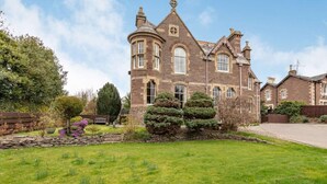 A large, historic stone building with multiple windows and a well-maintained lawn. - 1 Bed in Crieff (oc-87497) (Crieff)