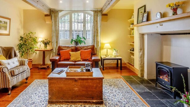 Ein gemütliches Wohnzimmer mit Kamin, einer Couch, einem Couchtisch und einem Bücherregal.