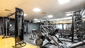 A gym with various exercise equipment, including weight machines and free weights.