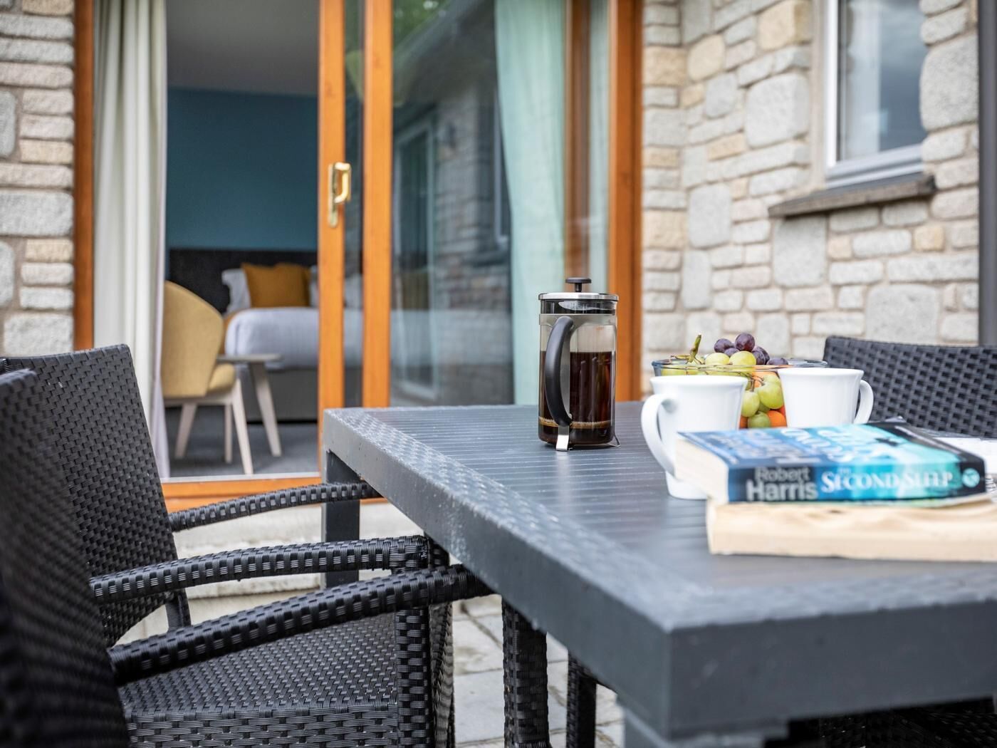 Ein Tisch mit einer Kaffeemaschine, einem Buch und einer Obstschale.