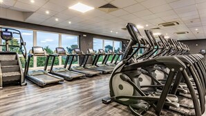 A gym with treadmills and exercise equipment, large windows, and a wooden floor. - 2 Bed in Saltash (oc-87706) (Saint Mellion)
