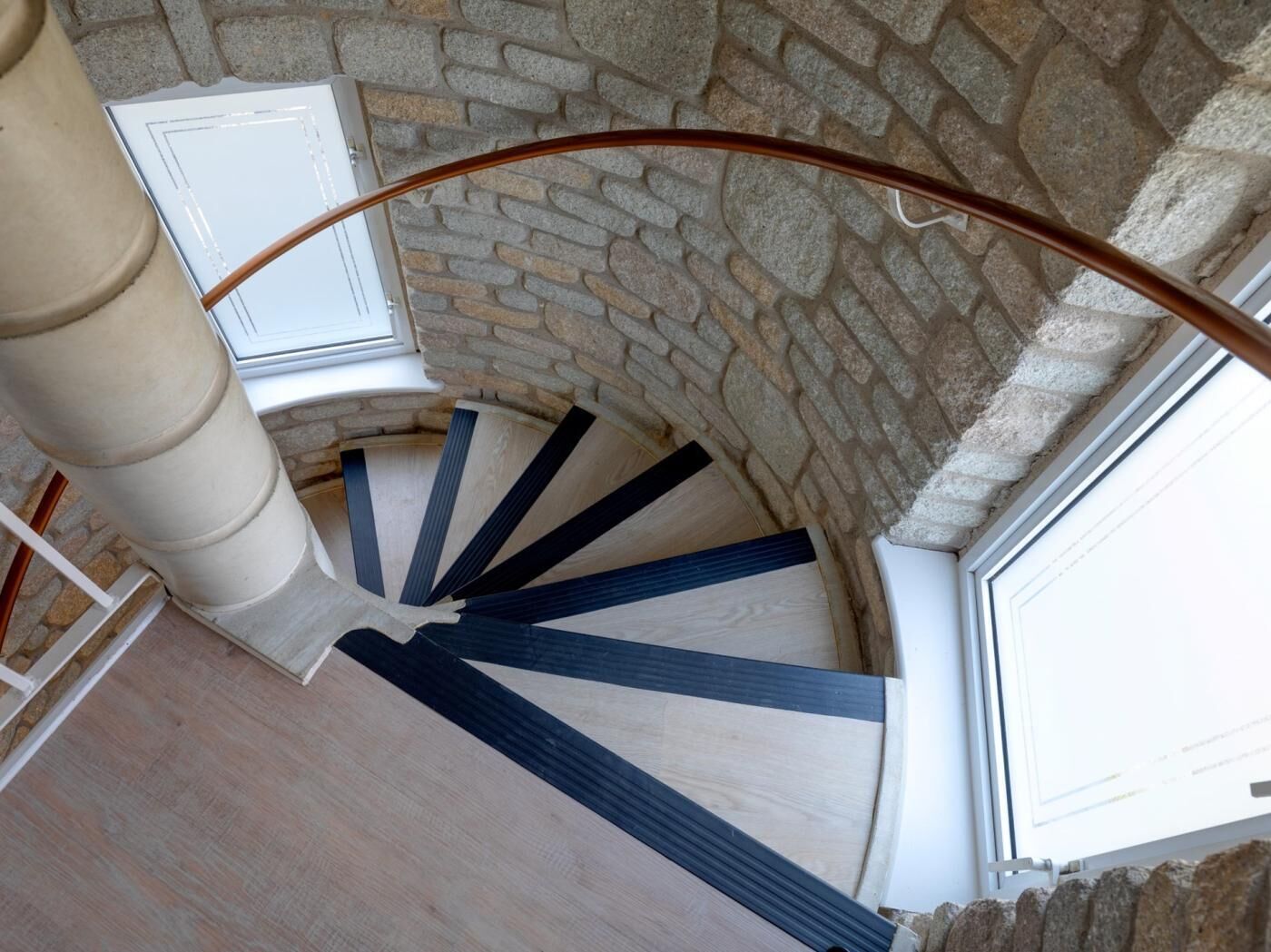 Gradi d'espiral amb paret de pedra i una finestra.