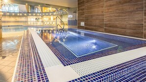 An indoor swimming pool with a tiled floor, a wooden wall, and a sunlit area with lounge chairs. - 2 Bed in Saltash (oc-87713) (Saint Mellion)