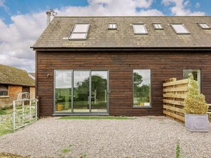 A modern wooden building with large windows and a gravel driveway. - 2 Bed in Blandford Forum (oc-88265) (Okeford Fitzpaine)