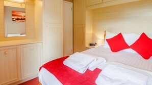 A hotel room with a bed, a nightstand, a mirror, and a wardrobe. - 2 Bed in Brixham (oc-88279) (Brixham)