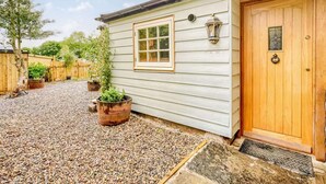 A house with a wooden door, a window, and a small porch area with gravel. - 2 Bed in Morpeth (oc-88270) (Rothbury)