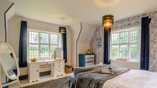 A bedroom with a bed, a dresser, a mirror, a window, and a ceiling light fixture. - 2 Bed in York (oc-88620) (Londesborough)