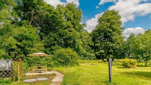 A garden with a paved path, a picnic table, and a covered area. - 2 Bed in York (oc-88620) (Londesborough)