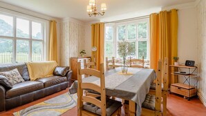 A cozy living room with a sofa, dining table, chairs, and a chandelier. - 2 Bed in York (oc-88620) (Londesborough)